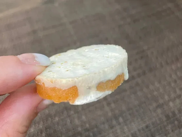 バゲットにチーズをのせたトッピング準備のアップ。手に持って厚みが分かるカット