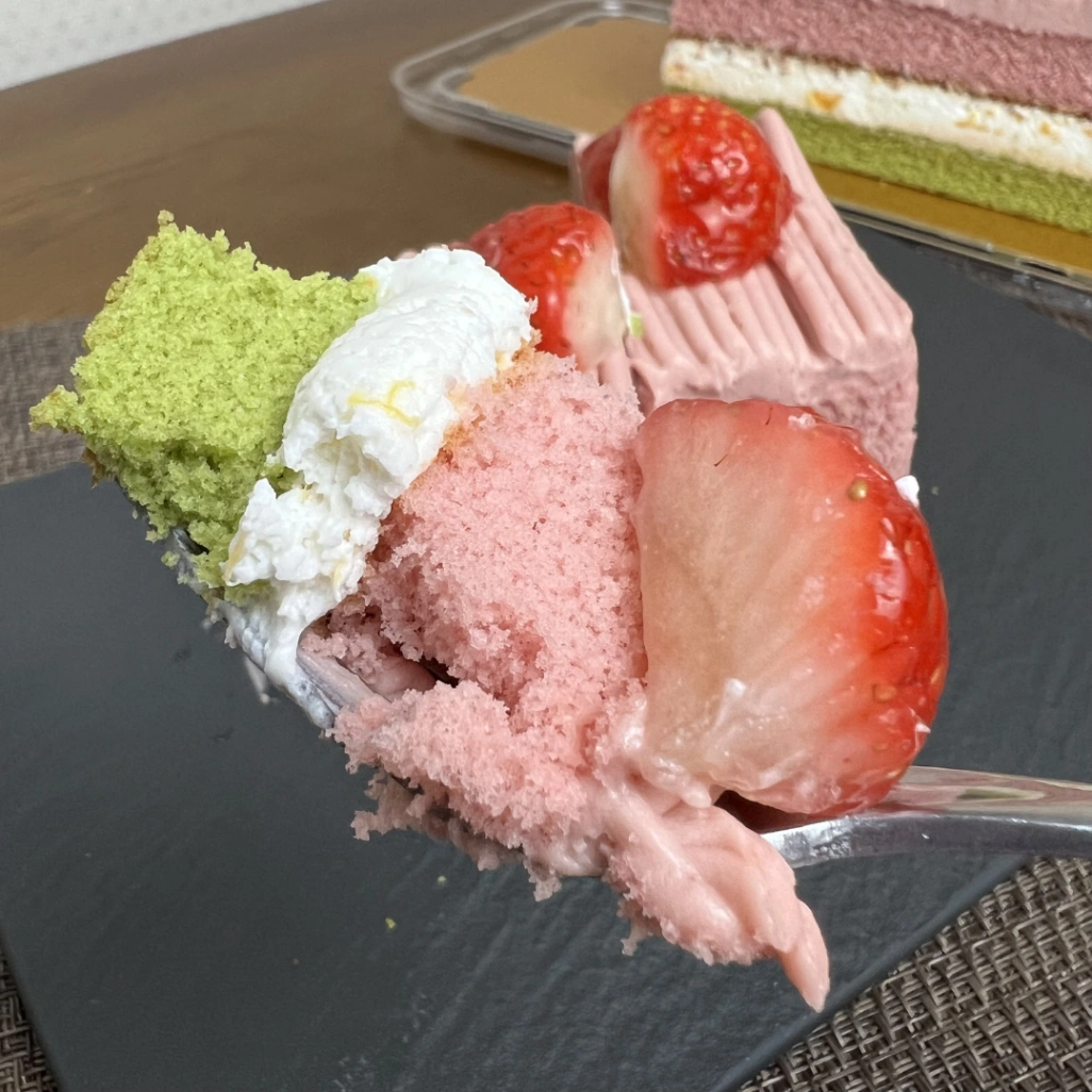 コストコのスプリングバーケーキをフォークで持ち上げた写真。いちごと3層の断面が見える