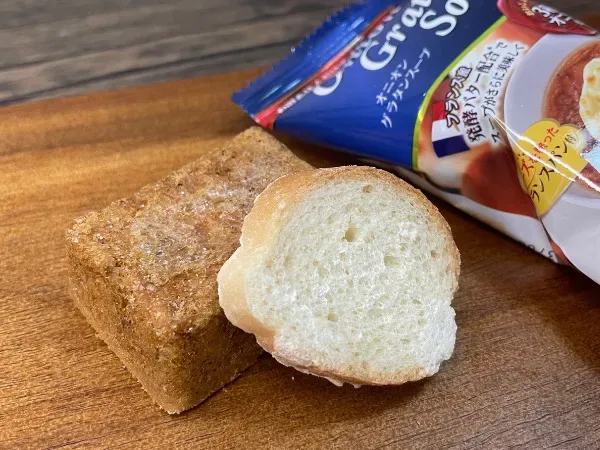 付属のバゲット(クルトン)を開封した様子。パンの断面と個包装スープが見える