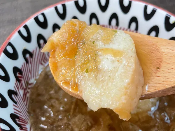 スプーンで持ち上げたチーズ入りバゲット。とろけたチーズの食感が伝わるアップ