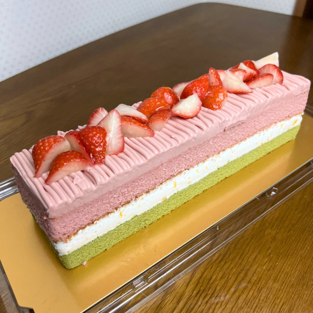 コストコのスプリングバーケーキ全体写真。いちごトッピングと3色の層がわかる
